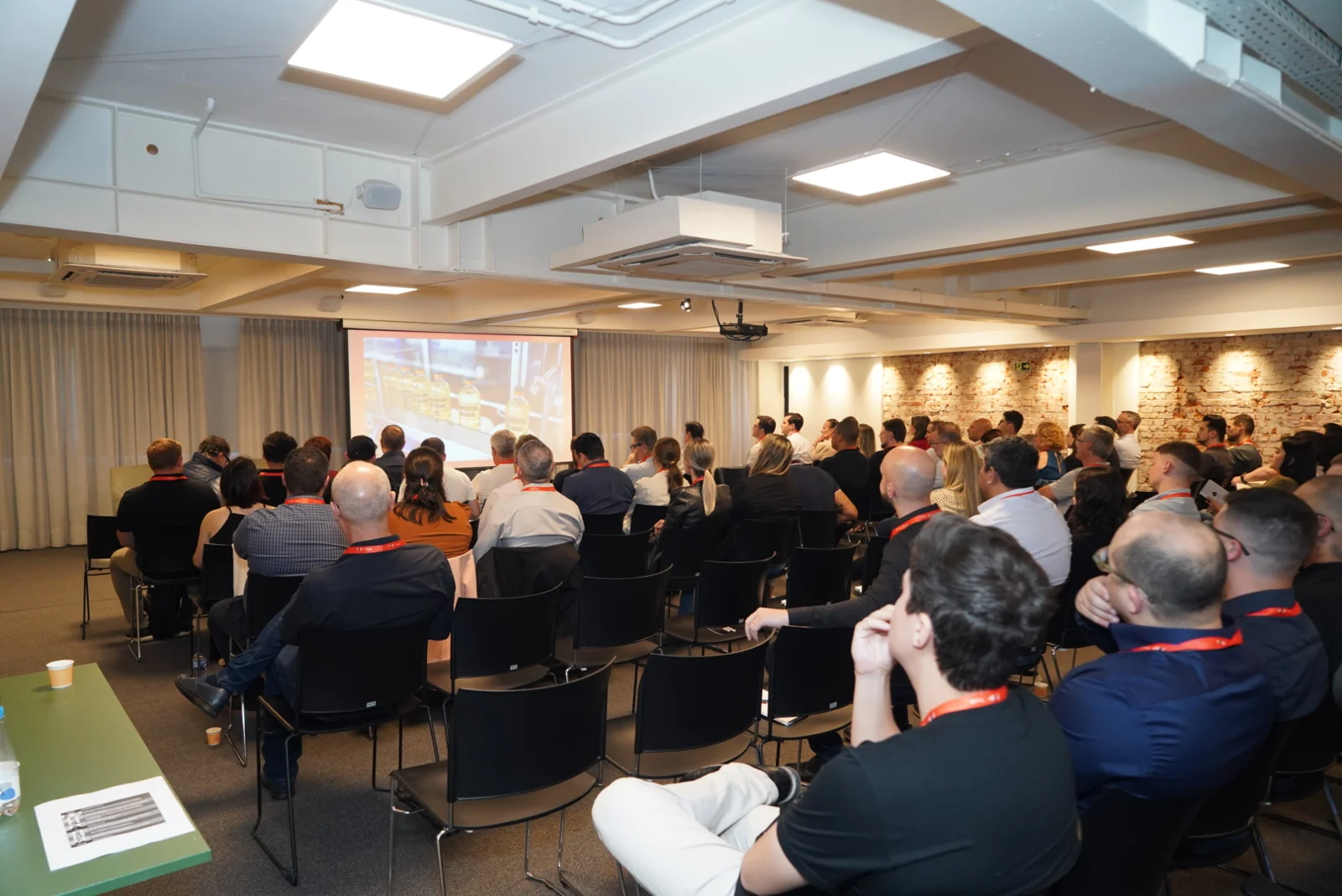 Participantes assistem apresentação em sala de eventos